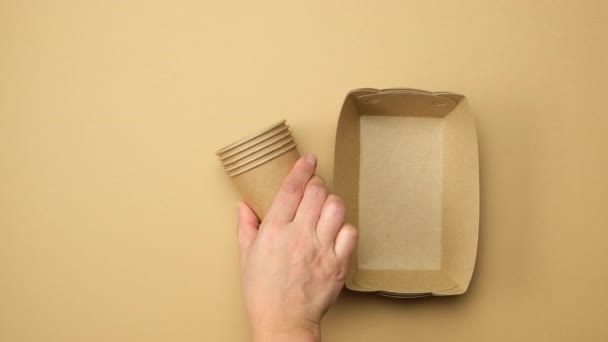 female hand puts disposable paper plates and cups, wooden forks and toothbrushes. No plastic concept - Filmati, video