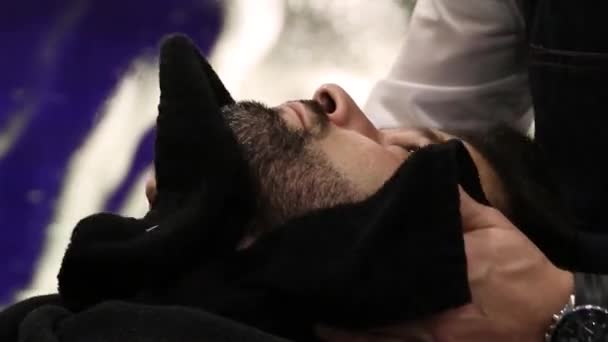 Barber place une serviette chaude sur le cou du client  - Séquence, vidéo