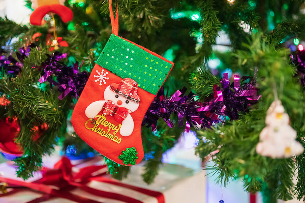 モミの木の上に飾られたクリスマスソックスのベビー新年の休日の背景 - 写真・画像
