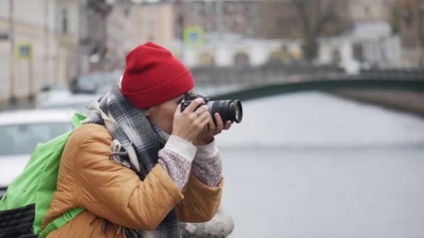 Junge Reisende aus dem Mittleren Osten fotografiert, während sie an einem kühlen Herbsttag am Fluss steht. - Filmmaterial, Video