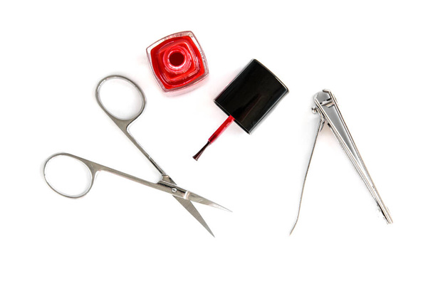 Forbici per manicure, forcipe e smalto rosso isolato su sfondo bianco. - Foto, immagini