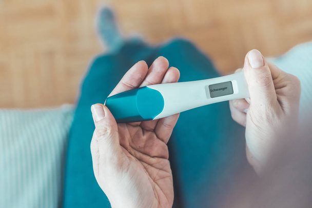 Woman hand holding pregnancy test, result is pregnant,Schwanger - Valokuva, kuva