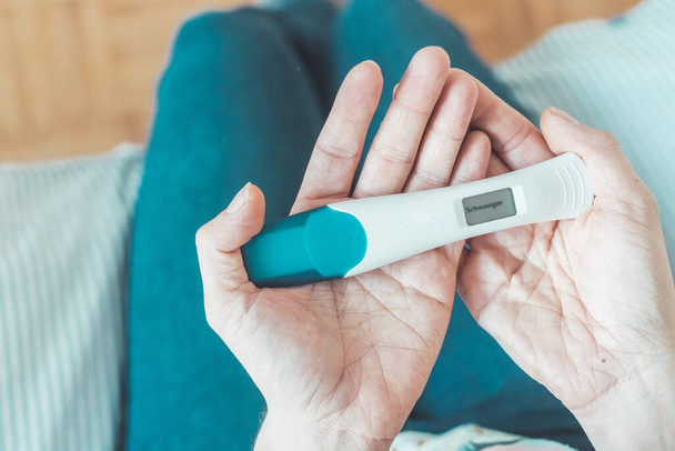 Woman hand holding pregnancy test, result is pregnant,Schwanger - Foto, Imagem