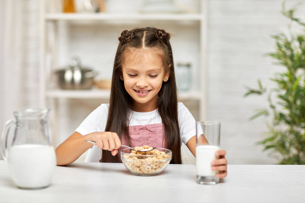 cute little girl eating breakfast: cereal with the milk - Zdjęcie, obraz