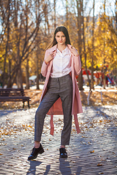 Full body portrait of young brunette girl in pink coat  - Photo, Image