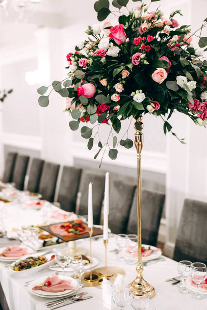 Mesa festiva con aperitivos y flores en el restaurante. Decoración de mesa de boda para invitados - Foto, Imagen