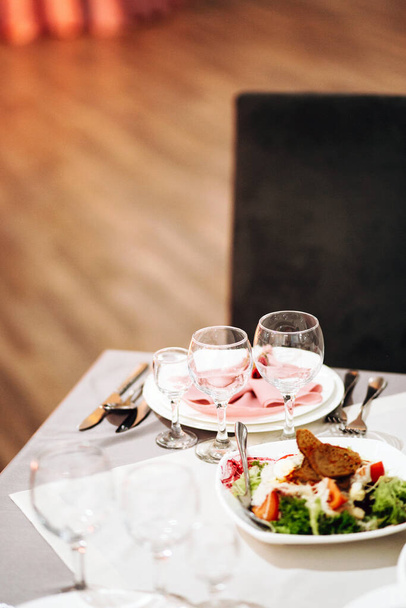 Feestelijke tafelschikking met snacks en bloemen in het restaurant. Bruiloft tafel decor voor gasten - Foto, afbeelding