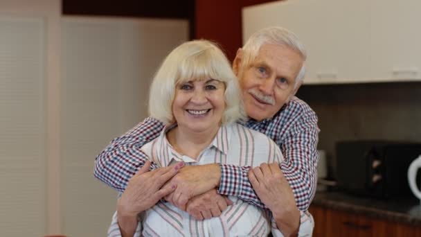 Senior couple retired grandparents husband and wife happy faces embracing at home, hugging, laughing - Footage, Video