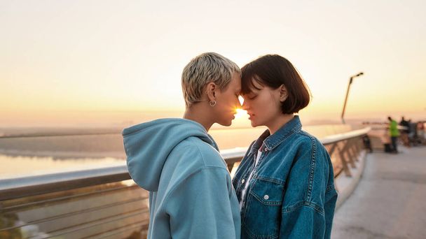 Young passionate lesbian couple going to kiss, Two girls enjoying romantic moments together at sunrise - Foto, imagen