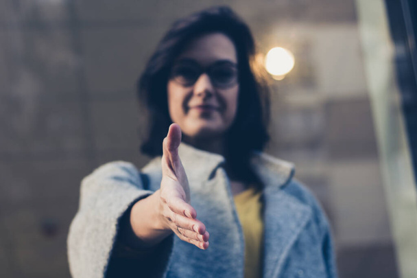 Close up of confident businesswoman introducing herself and giving a handshake. - Foto, afbeelding