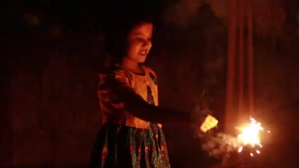 um bonito indiana menina criança desfrutando sparklers durante diwali festival - Filmagem, Vídeo