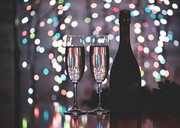 egy sötét üveg bor egy gyönyörű ünnepi bokeh háttér, álló színes nem fókusz fények egy sötét háttér - Fotó, kép
