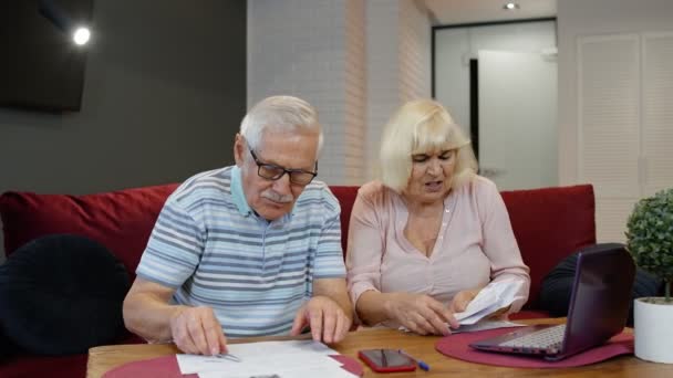 Senior couple checking papers, domestic bills, planning budget investment loan insurance payment - Záběry, video