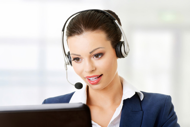 Beautiful young call-center assistant smiling - Foto, Imagen