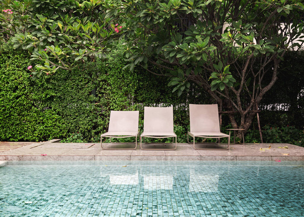relax outdoor seat next to decking around outdoor swimming pool on resort  - Photo, Image