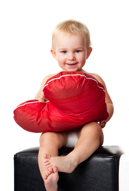 Beautiful baby sitting with heart shaped red pillow - Foto, immagini