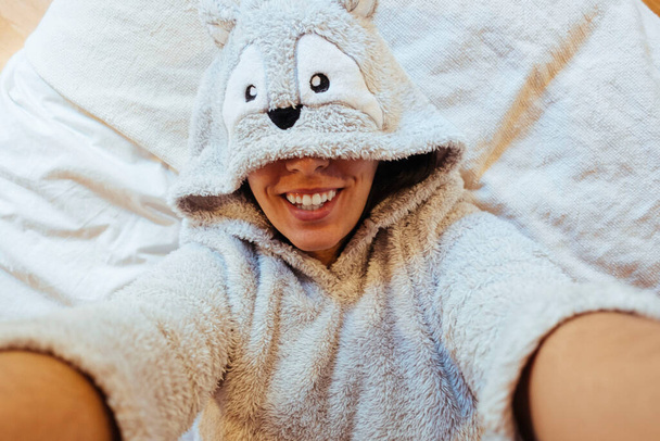 Nuori nainen ottaa selfie sängyssä hänen kasvonsa peitetty hänen pyjama silmät - Valokuva, kuva