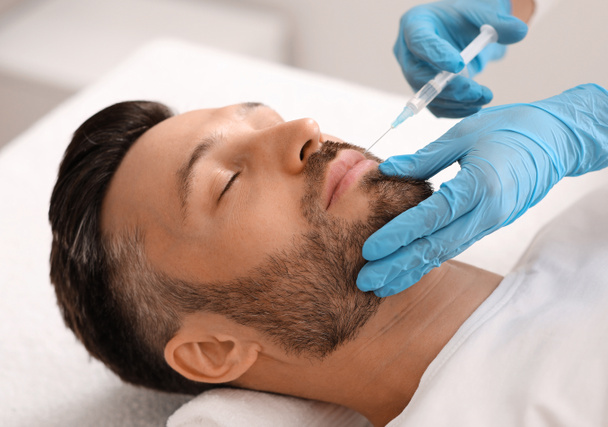 Attractive man visiting aesthetic clinic, getting lips filler - Photo, Image