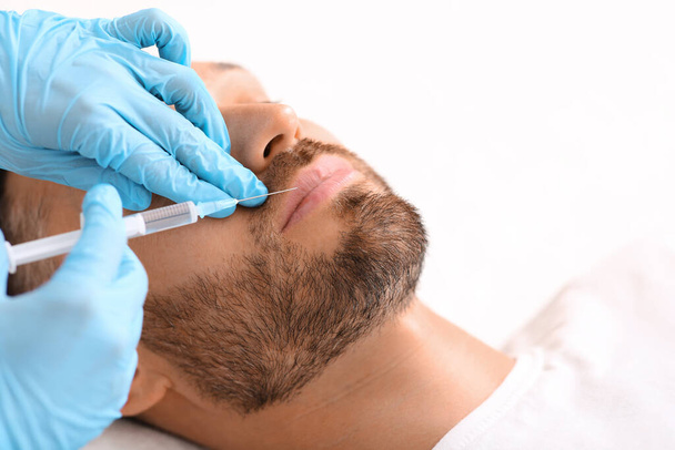Closeup of man getting lips filler at aesthetic clinic - Photo, Image