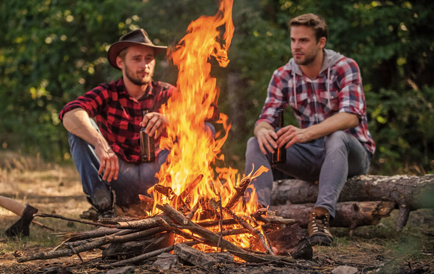 warm and cosy. family camping. hiking adventure. picnic in tourism camp. happy men brothers. friends relaxing in park together. drink beer at picnic. campfire life story. spend free time together - Фото, изображение