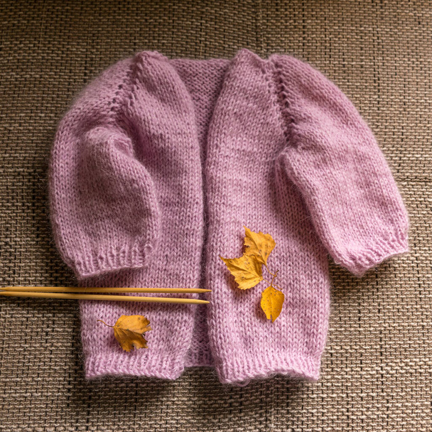 żakiet z dzianiny dla dziewczynki, różowy kolor, tekstura dzianiny, koncepcja rękodzieła, ręczna robótka ręczna, jesienny czas dzianiny - Zdjęcie, obraz