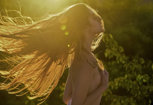 Long hair. Erotic sunset. Her perfect style. Summer outdoor lifestyle. Happy young woman posing over sun rays. Pretty woman silhouette and backlight. Summer outfit. Beautiful girl. Fashion style - Foto, afbeelding