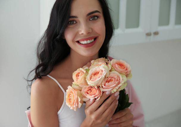 Young woman with beautiful bouquet in kitchen - Foto, imagen