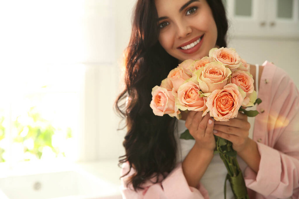 Young woman with beautiful bouquet in kitchen - Foto, imagen