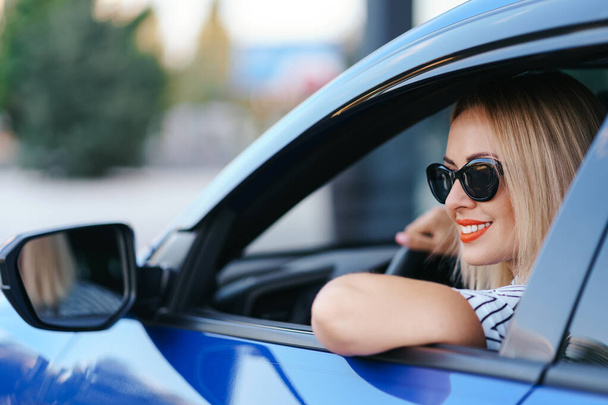 Kobieta w okularach słonecznych prowadzi samochód - Zdjęcie, obraz