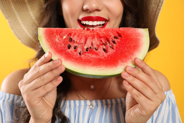 Beautiful young woman with watermelon on yellow background, closeup - Fotografie, Obrázek