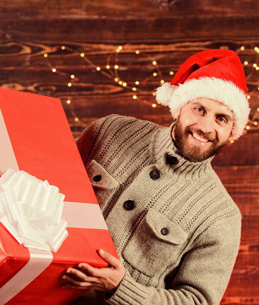 I am here to give present. Delivering happiness to your home. Delivery service. Spread happiness. Giving happiness. Winter happiness. Happy holidays. Santa Claus. Smiling guy with giant gift box - Foto, afbeelding
