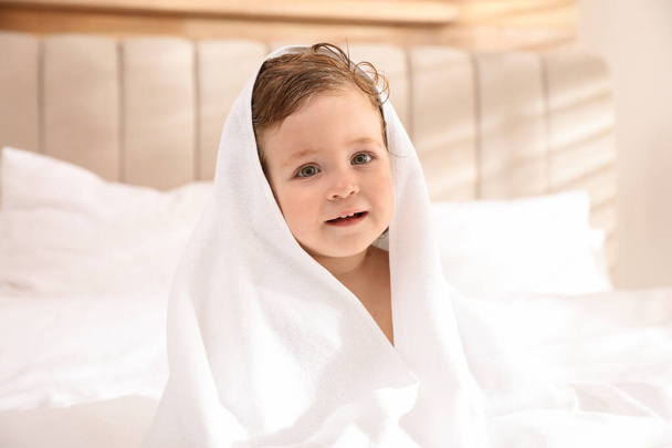Cute little baby with soft towel on bed after bath - Фото, зображення