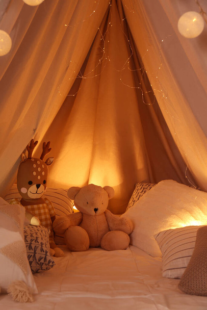 Play tent with toys and pillows indoors, closeup. Modern children's room interior - Фото, изображение