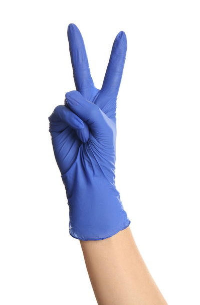 Woman in blue latex gloves showing two fingers on white background, closeup of hand - Foto, afbeelding