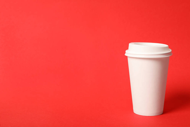 Kırmızı arka planda paket kağıttan kahve fincanı. Metin için boşluk - Fotoğraf, Görsel