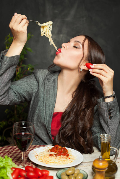 Attractive woman eating testy italian pasta in restaurant - Фото, изображение