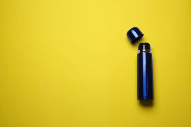 Blue thermos on yellow background, top view. Space for text - Foto, Imagem