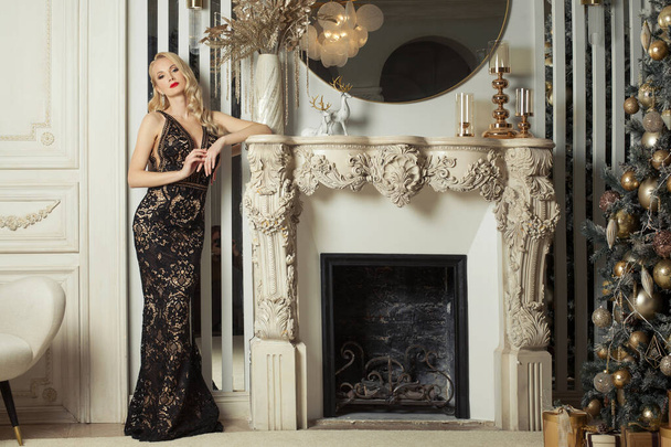 Christmas woman in glamorous evening dress at home. Christmas holiday and New Year party concept - Photo, Image
