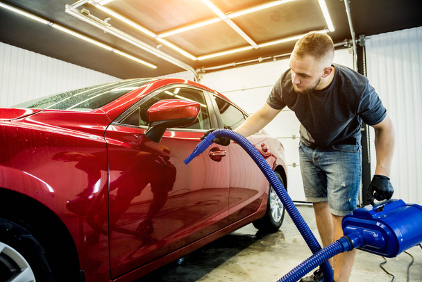Service worker makes automatic drying of the car after washing. - Foto, imagen