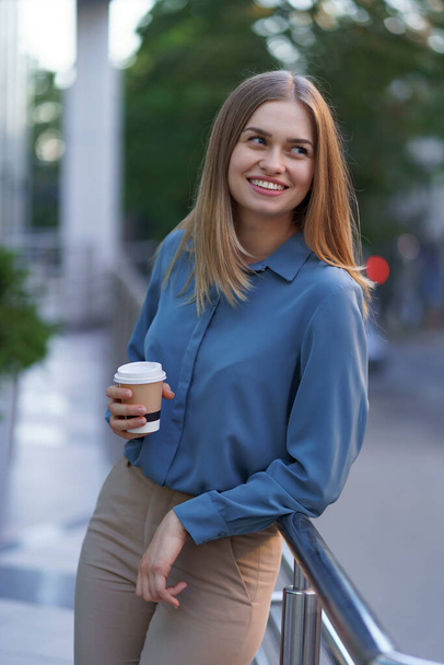 Χαρισματική γυναίκα που πίνει καφέ για να πάει στη δουλειά. - Φωτογραφία, εικόνα