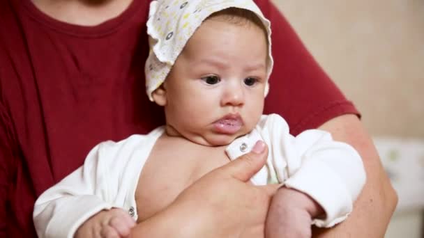 Primer plano de lindo bebé sorprendido Niño en brazos de las mamás - Metraje, vídeo