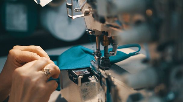 Woman seamstress works at a sewing machine - Фото, изображение