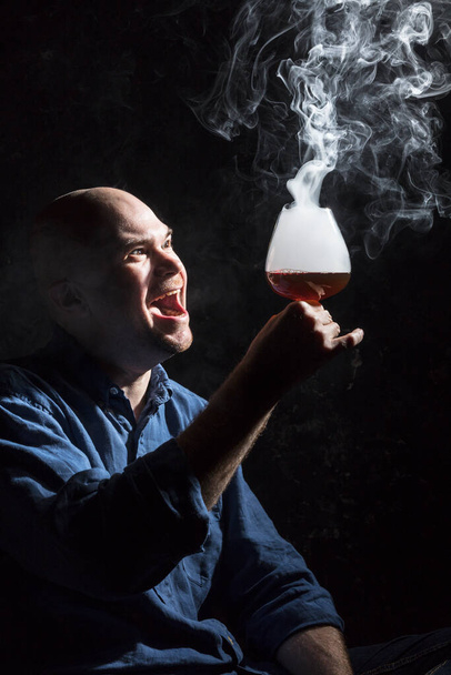 Solid bald man in shirt with glass of whisky and fume studio portrait. - Zdjęcie, obraz