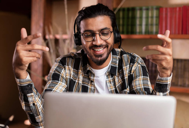 Indian guy having video call at laptop sitting at home - Photo, Image
