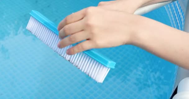 dziewczyna montaż szczotki do basenu, basen czyszczący ze specjalnym pędzlem - Materiał filmowy, wideo