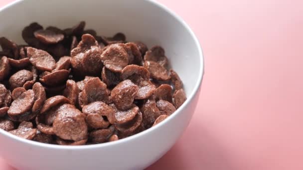 close up of chocolate corn flakes in a bowl on pink  - Footage, Video