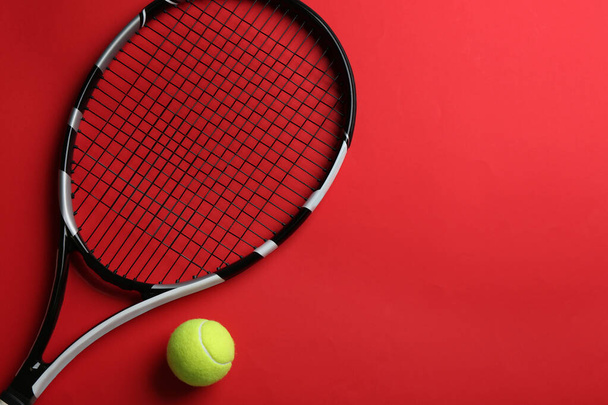 Tennis racket and ball on red background, flat lay. Space for text - Photo, Image