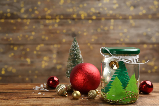 Handmade snow globe and Christmas decorations on wooden table, space for text - Φωτογραφία, εικόνα