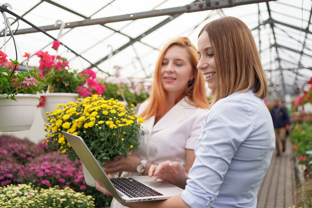 Two business women having a conversation while visiting greenhouse - Valokuva, kuva