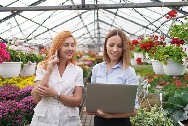 Two business women having a conversation while visiting greenhouse - Valokuva, kuva